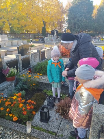 Modlitwa i zapalanie zniczy na cmentarzu